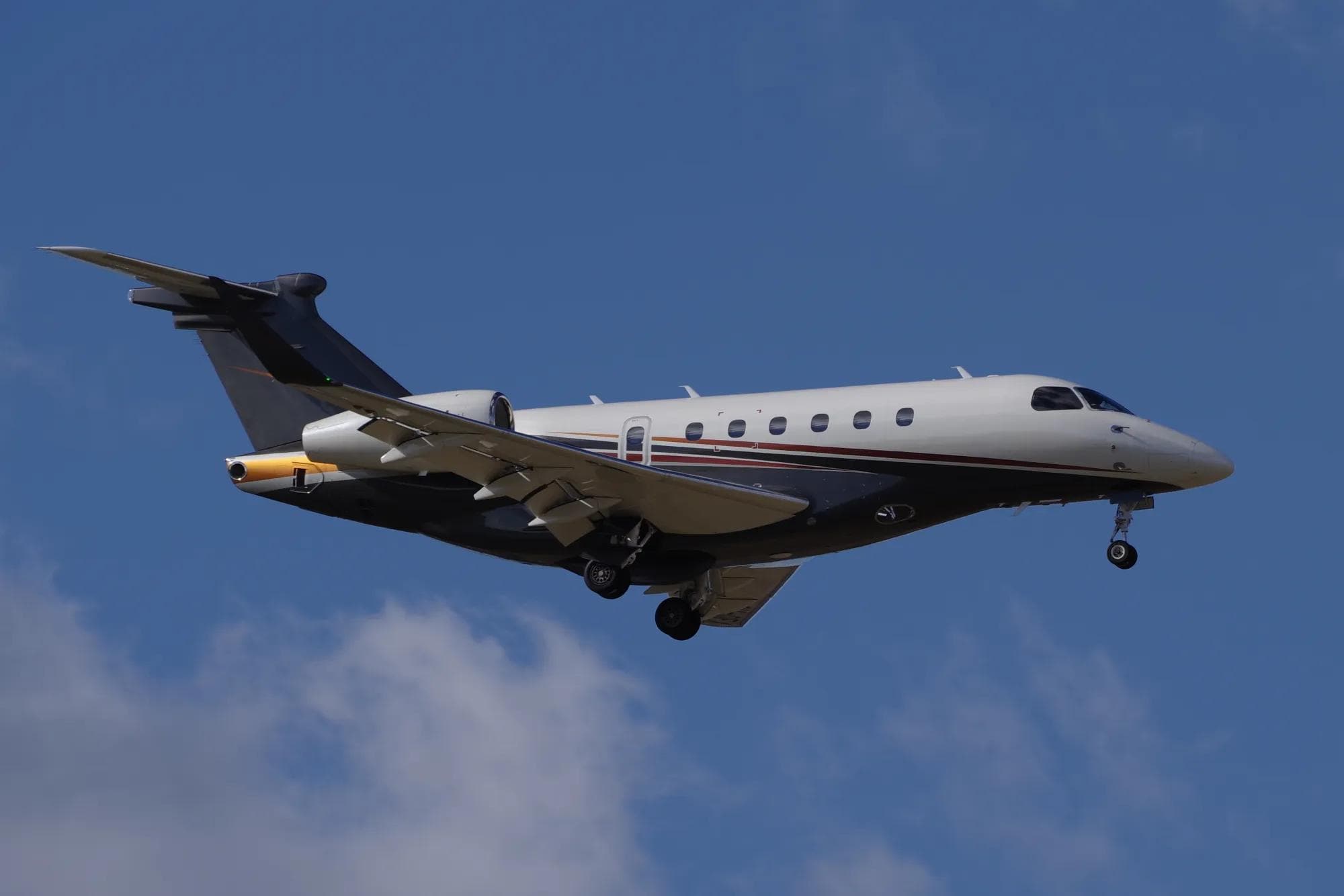 Embraer Praetor 600E super-midsize business jet in flight, three-quarter front view against a clear blue sky
