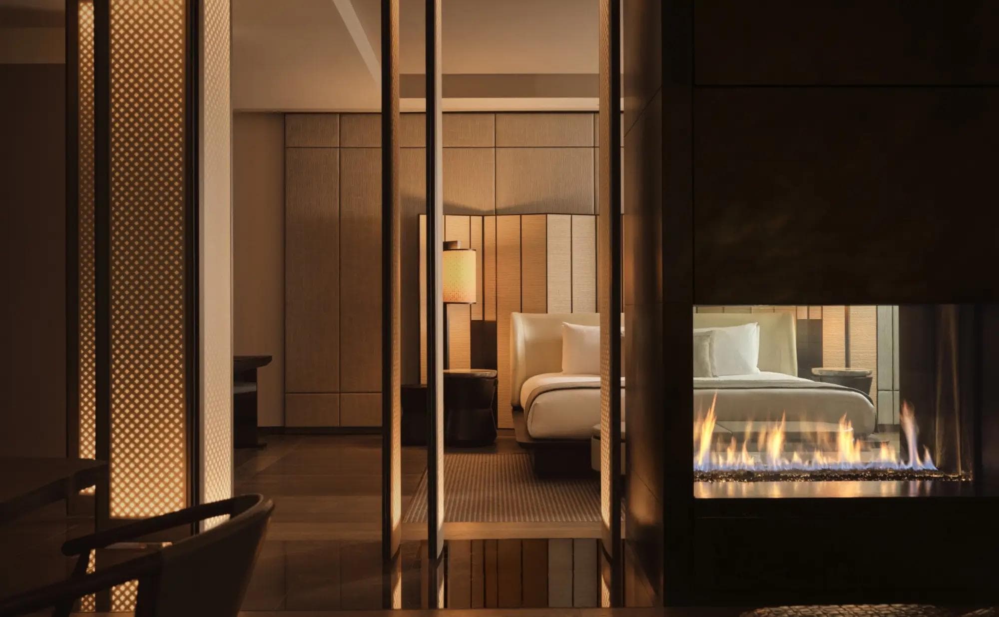 Aman New York Corner Suite interior with floor-to-ceiling windows, restrained minimalist palette, and Fifth Avenue views