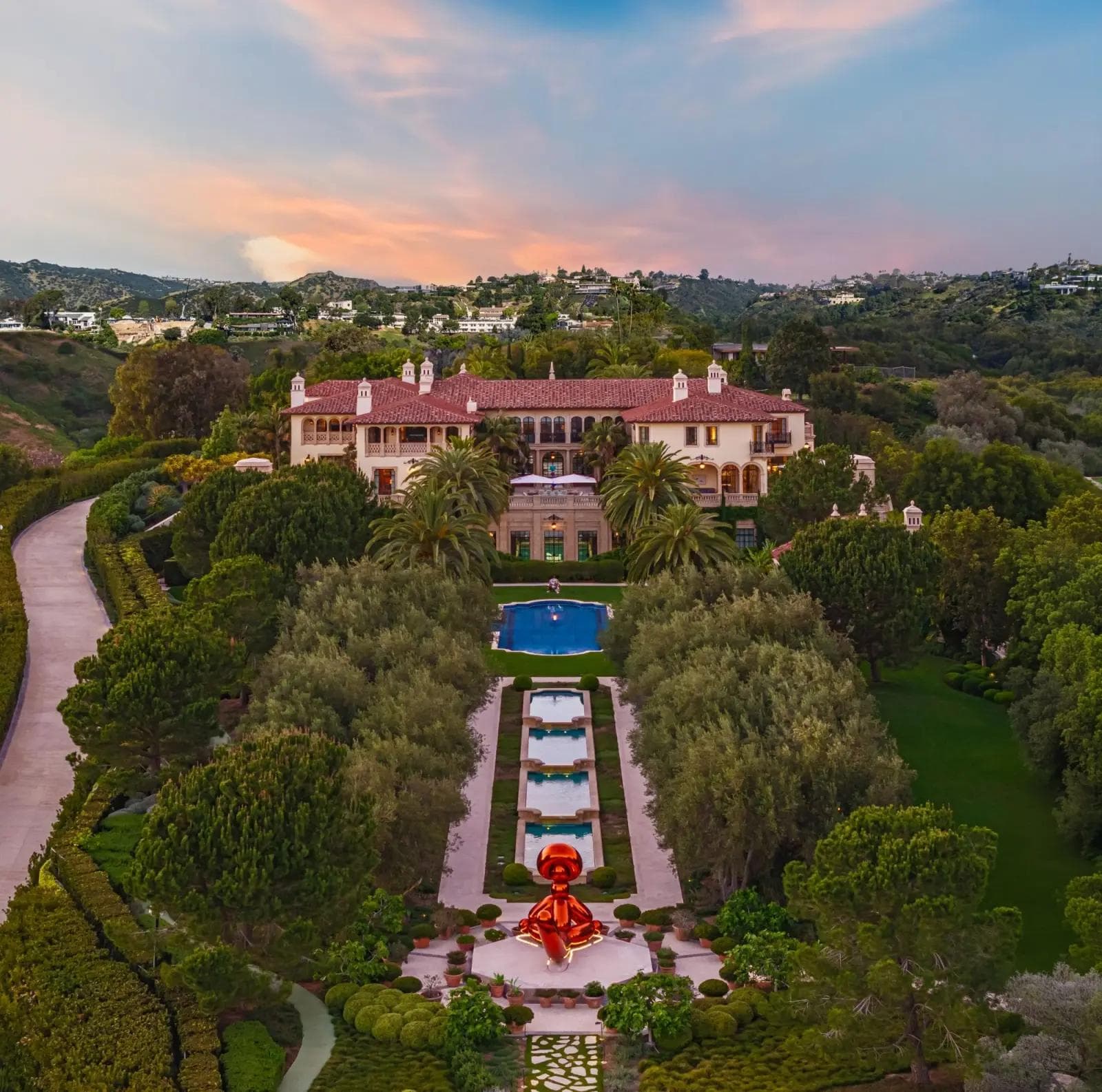Aerial view at dusk of the 11201 Chalon Road Bel Air estate, Italian Renaissance-style architecture across an 8-acre hilltop with reflecting pools and outdoor sculpture
