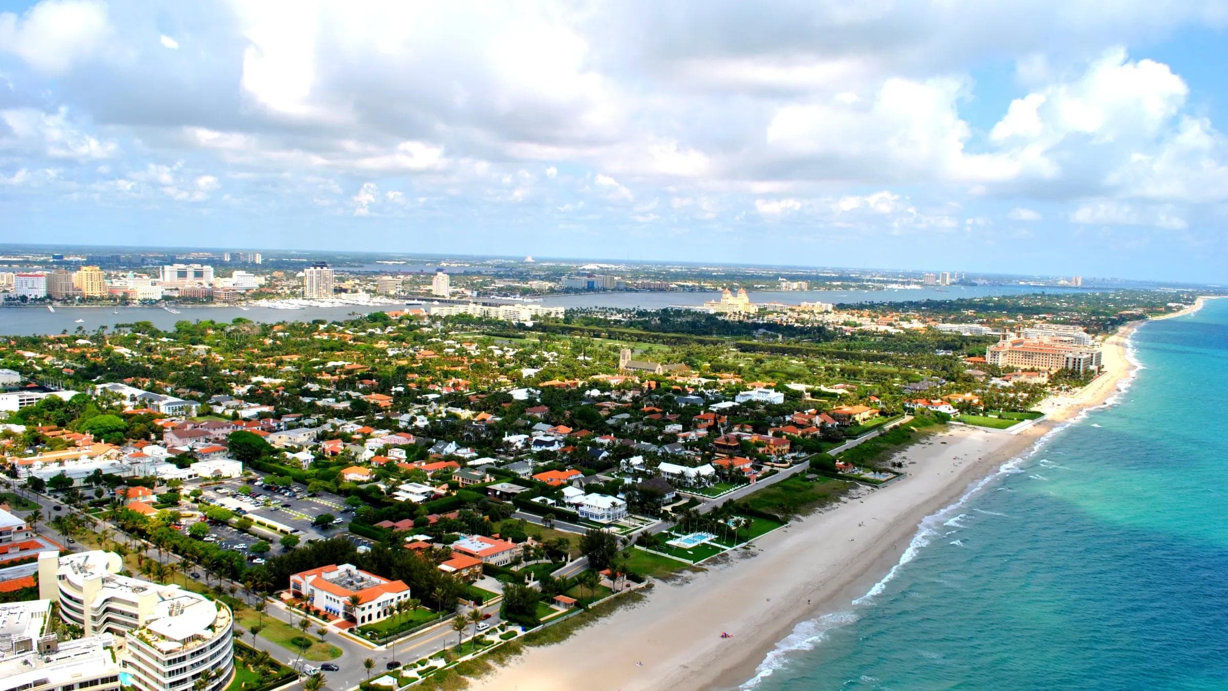 Aerial view of the Town of Palm Beach, Florida, showing Atlantic Ocean beach on the right and Intracoastal Waterway on the left with residential estates between them
