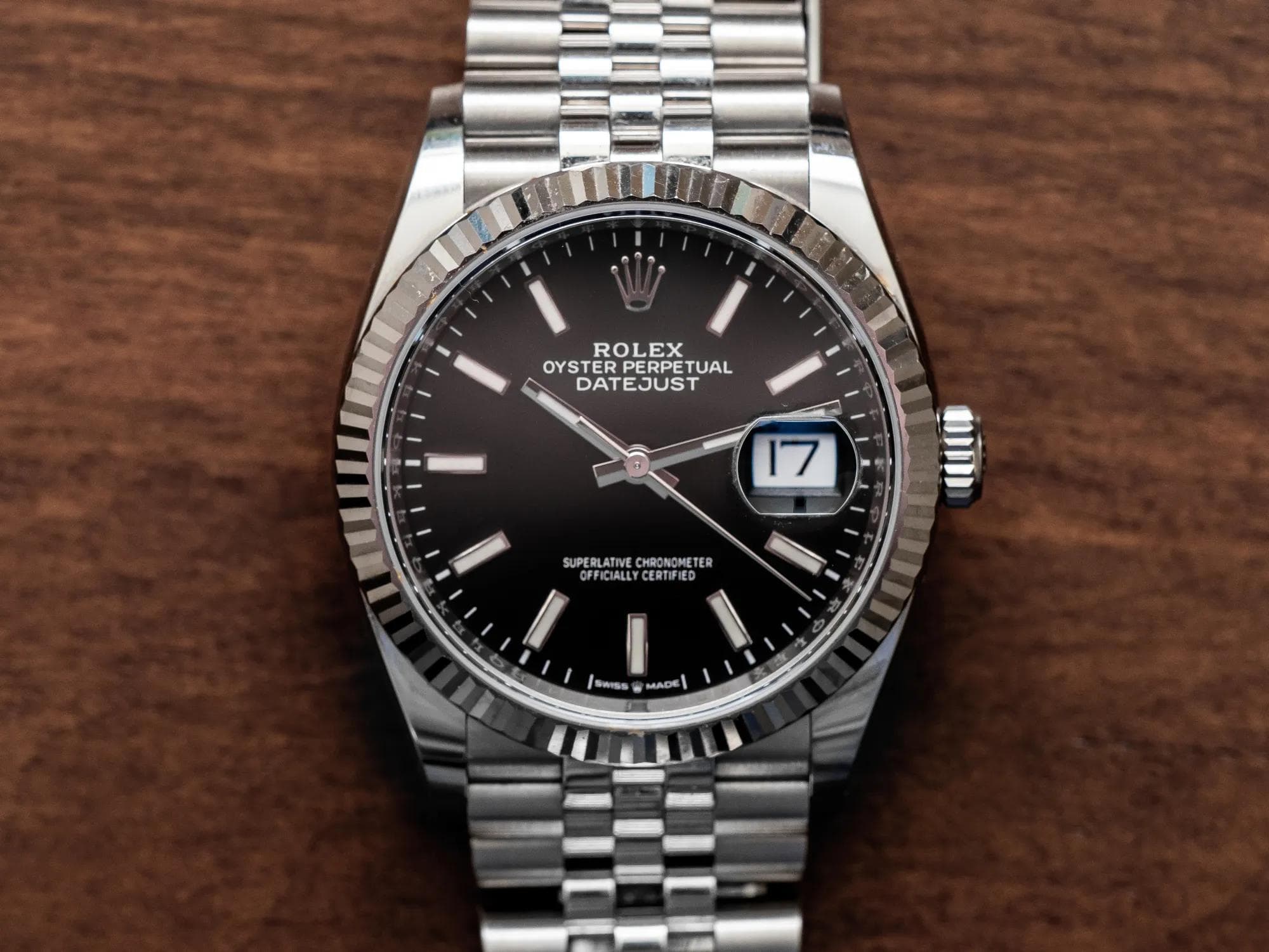 Rolex Oyster Perpetual Datejust 126234 in steel with a black dial, fluted white-gold bezel, and Jubilee bracelet